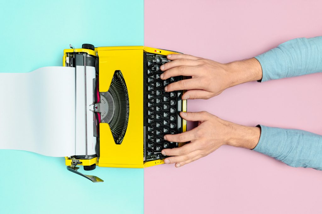 Kuvassa vanhanaikainen kirjoituskone ja kädet
